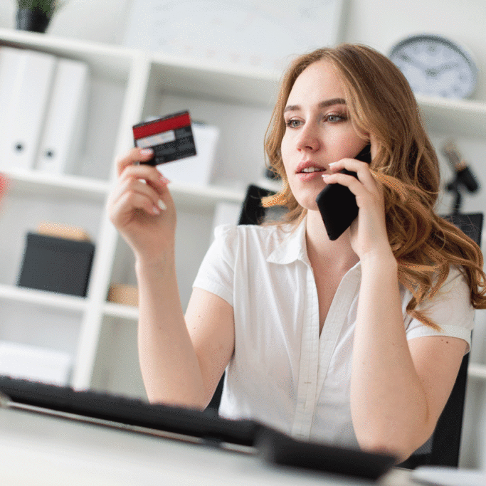 Woman on the phone looking at her credit card.